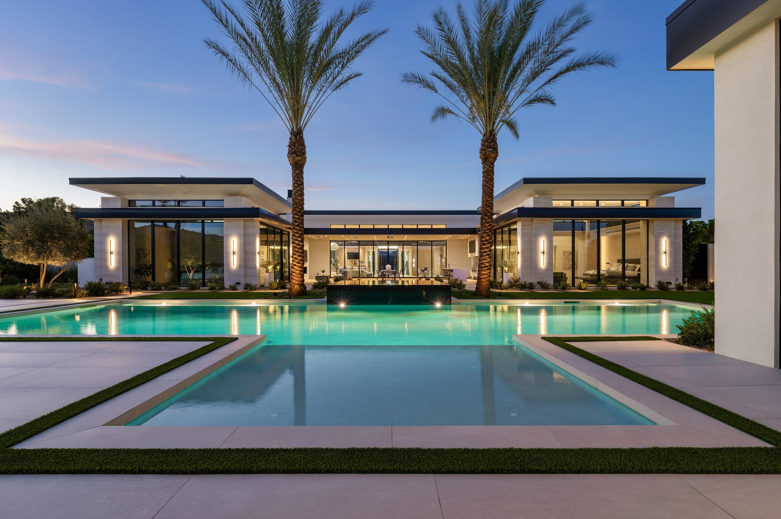 Ocotillo residence — a long pool and black-edge spa between two date palms at dusk