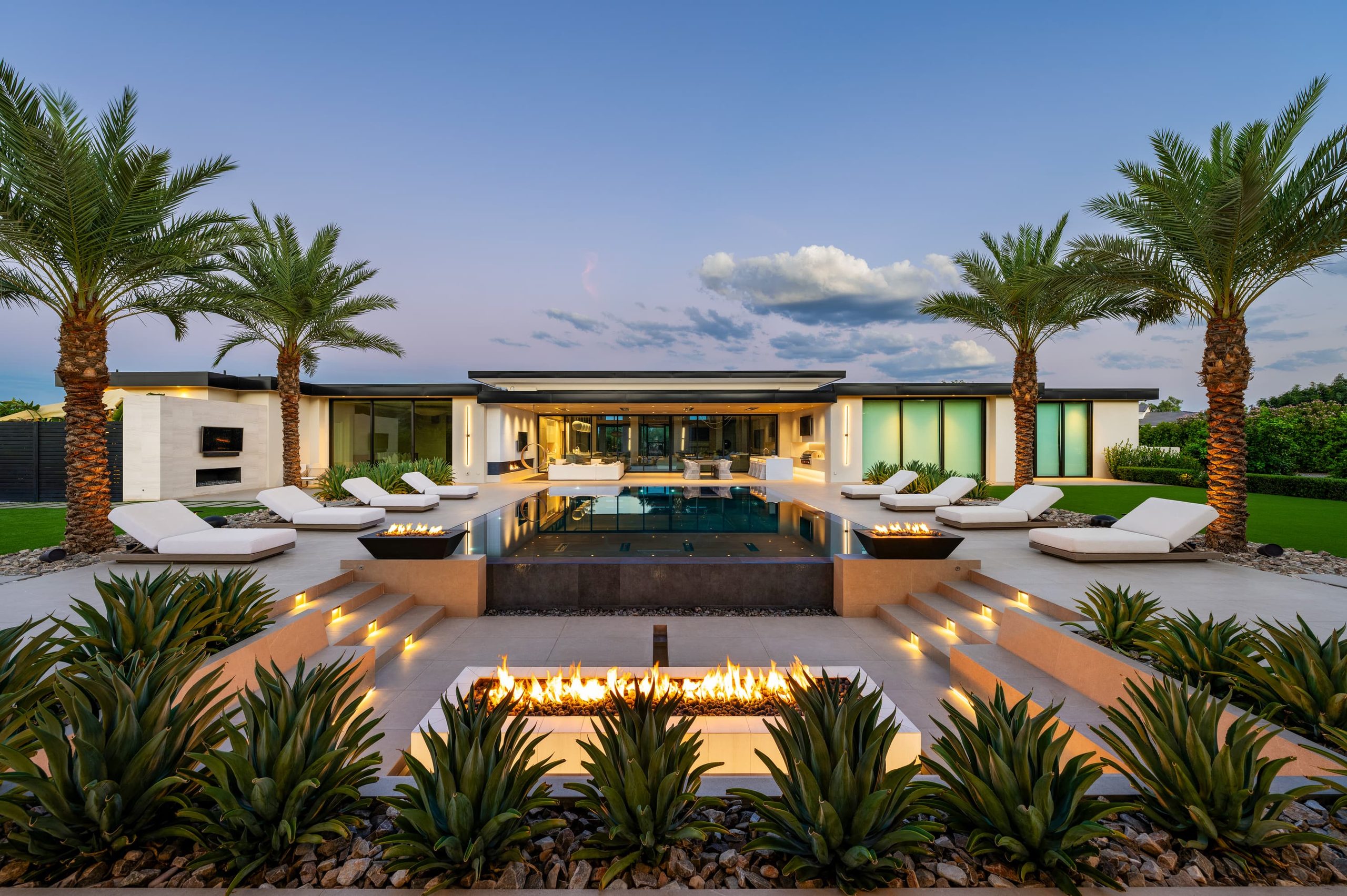Pool and shade pavilion under palms at dusk