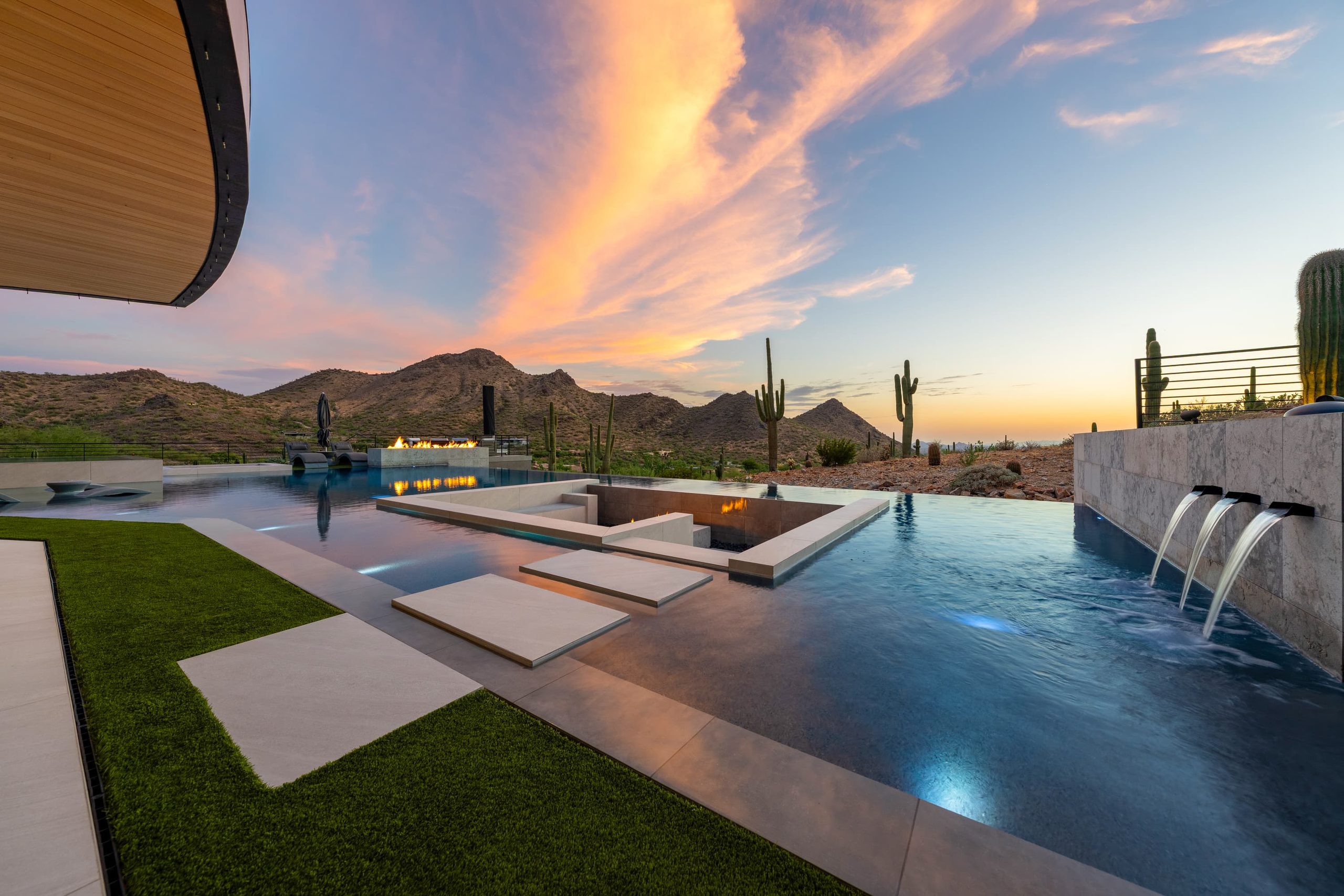 Hillside infinity pool with raised spa at sunset