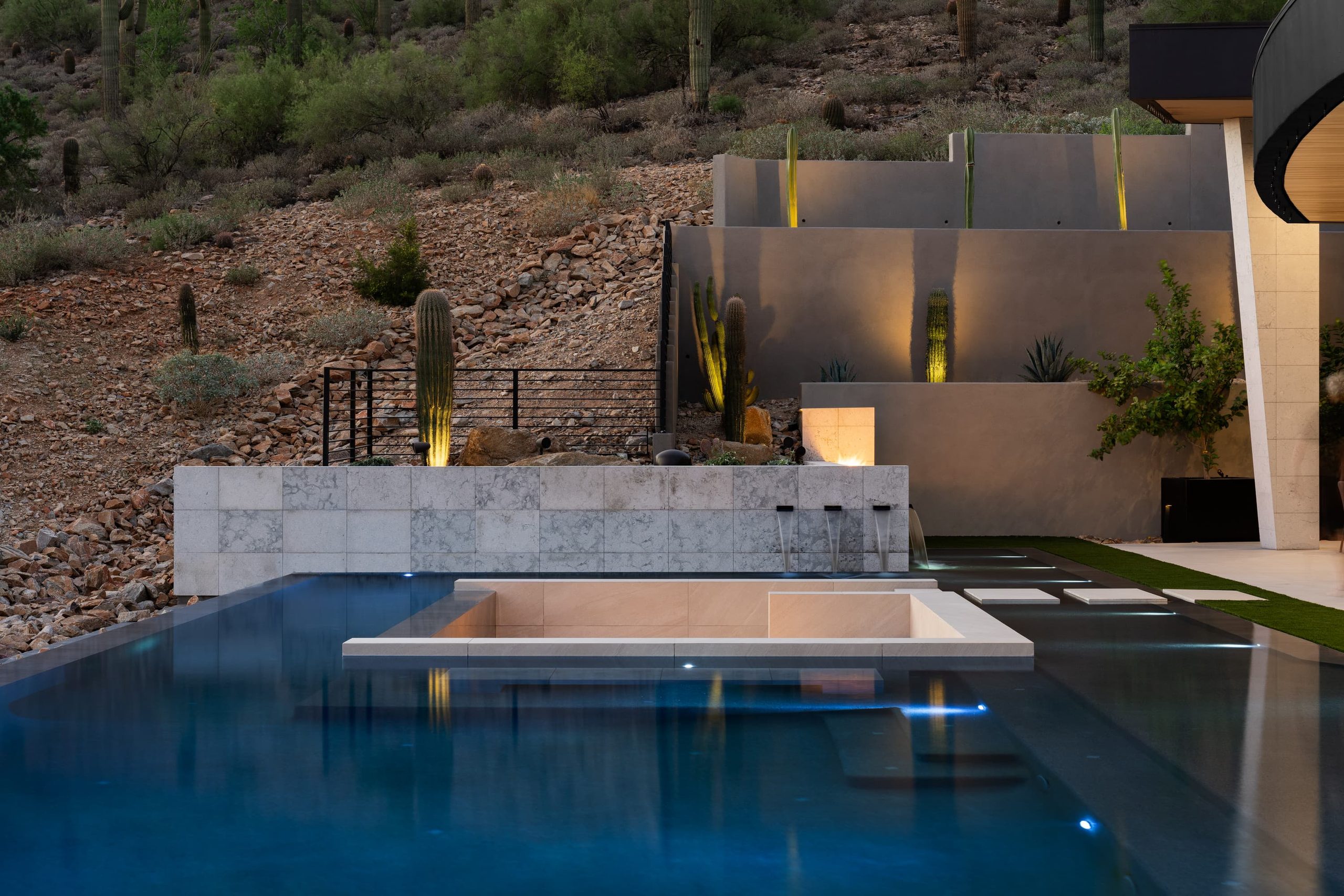 Spa water in transit over a stone weir, lit at night