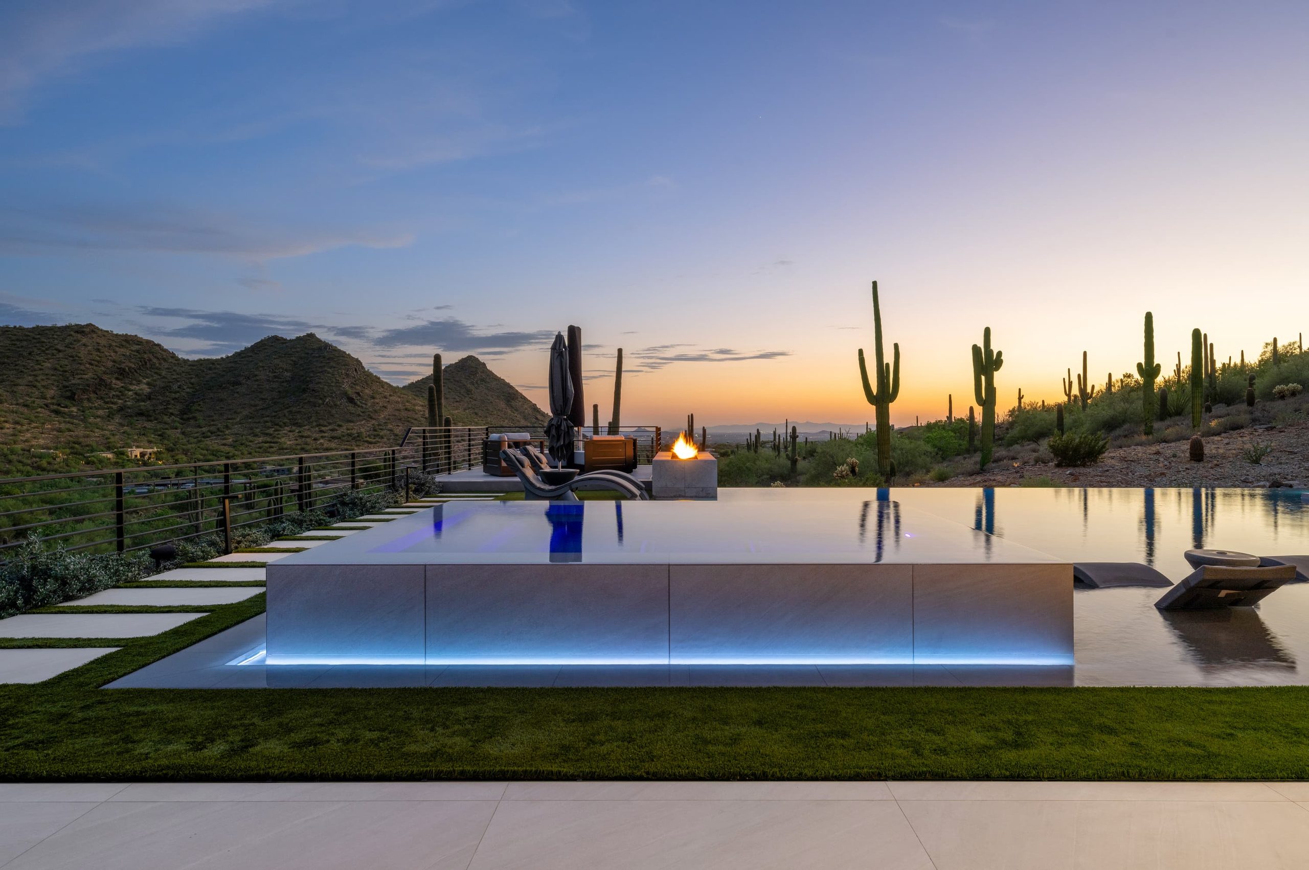 Infinity-edge pool at dusk on a North Scottsdale hillside, the water holding the sky